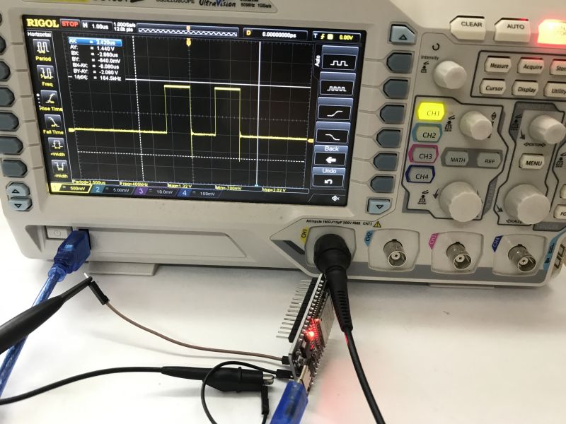 ESP32 Signal Waveform Analysis on Oscilloscope Oscilloscope displaying signal waveform with connected ESP32.