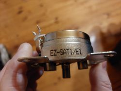 Metalowa głowica satelitarna z oznaczeniem EZ-SAT1/E1 trzymana w dłoni