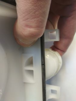Zbliżenie na plastikowy element odkurzacza trzymany przez dłoń.