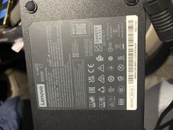 Zasilacz Lenovo 300W leżący na siedzeniu pojazdu.