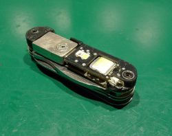 Scyzoryk z wbudowaną płytką PCB i diodami LED, leżący na zielonej macie