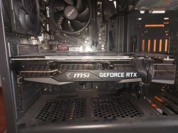 Widok wnętrza komputera z kartą graficzną MSI GeForce RTX i elementami płyty głównej.