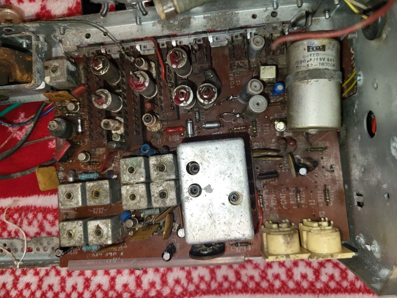 Wnętrze starego odbiornika radiowego z widocznymi kondensatorami i układami