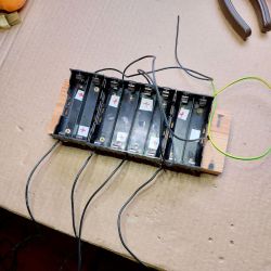 Battery Cell Connection Structure Structure for parallel connection of battery cells on a cardboard surface.