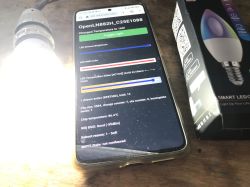 Controlling a WiFi LED Lamp with OpenLN882H Firmware Smartphone displaying control interface for OpenLN882H WiFi LED lamp next to a lit LED bulb and its box.
