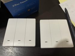 White Touch Wall Switches Two white, touch wall switches on a black surface.
