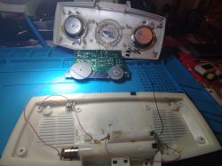 Otwarte urządzenie elektroniczne z widocznymi głośnikami, przewodami i obudową.