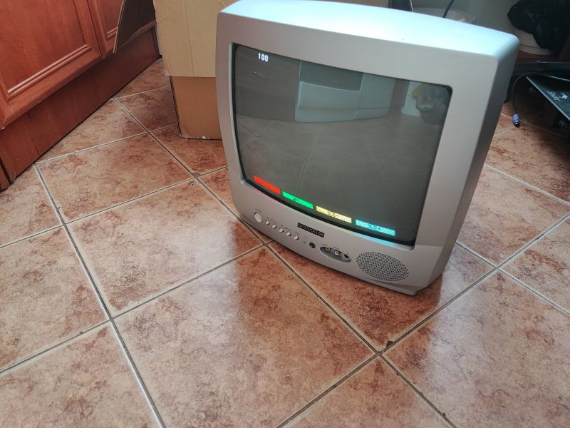 Telewizor kineskopowy Daewoo K14C5GT na podłodze, z widocznym ekranem i przyciskami na panelu przednim.