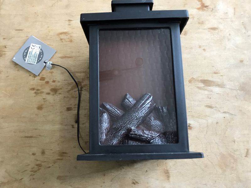 Prosty ozdobny mini kominek LED z drewnianymi elementami wewnątrz.