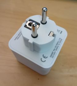 White Electrical Plug with Certifications White electrical plug with certification markings on a wooden surface.