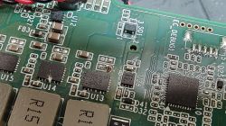 Zbliżenie płytki PCB z układami SMD; widoczny przypalony pad lutowniczy obok U13