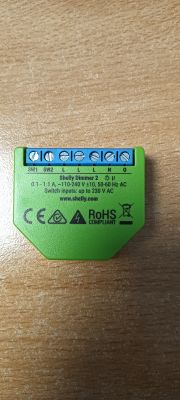 Green Shelly Dimmer 2 module on wooden surface with visible screw terminals