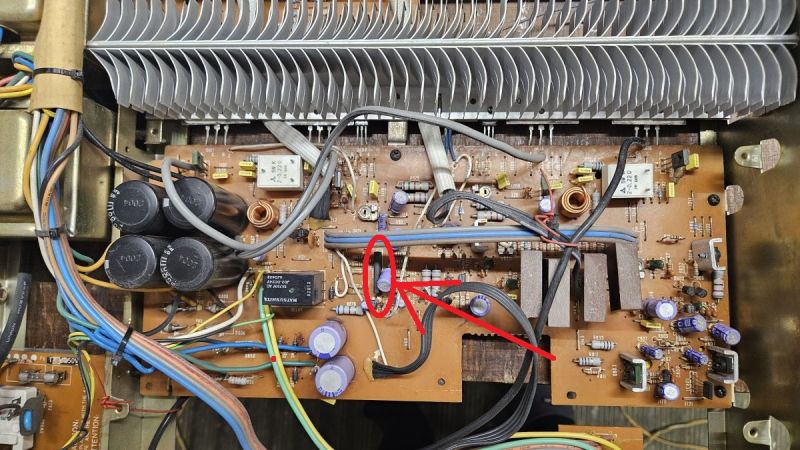 Zbliżenie na płytkę PCB ze strzałką wskazującą układ scalony oznaczony jako AN7060.