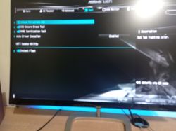 Nieostre zdjęcie ekranu BIOS z zakładką „Tool” płyty głównej ASRock.