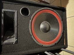 Czarna kolumna głośnikowa z dużym wooferem z czerwonym zawieszeniem, tubą i okrągłym portem bass-reflex
