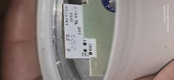 Close-up of a bulb PCB with solder pads labeled “TX2” and “RX1” next to a white label with numbers.