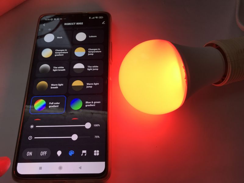Pairing RGB/CCT Bulb with Tuya App Smartphone with Tuya app next to a colorful RGB/CCT LED bulb