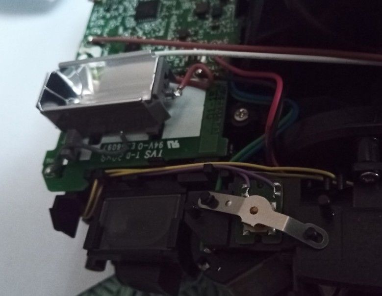 Wnętrze aparatu: płytka PCB, przewody i metalowy element przy mechanizmie przycisku