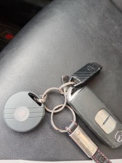 Zbliżenie na kluczyk samochodowy i brelok immobilizera na czarnym tle.