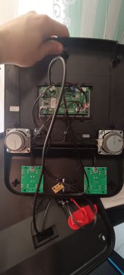 Wnętrze urządzenia elektronicznego z widocznymi obwodami i głośnikami.