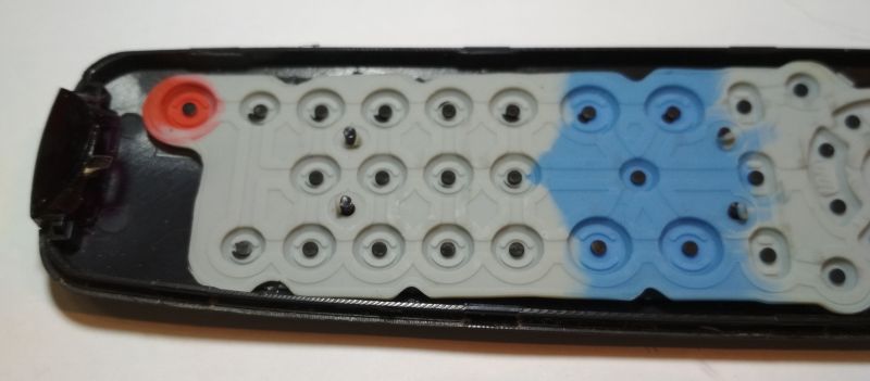 Wnętrze pilota do telewizora z widoczną gumową klawiaturą.