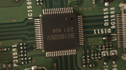 Zbliżenie na układ scalony na zielonej płytce PCB z oznaczeniami IC1501.