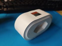 Woolley SA-032 Smart Plug White smart plug lying on a blue surface.