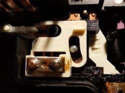 Zbliżenie na wnętrze naprawianego przełącznika zespolonego z metalowym sztyftem.