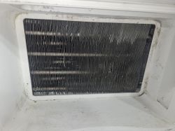 Zbliżenie na zabrudzony skraplacz suszarki bębnowej Beko z widocznymi kroplami wody.