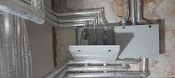 Skrzynka instalacyjna z podłączonymi izolowanymi rurami.