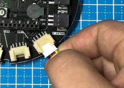 Connecting Cable to Arduino MKR IoT Carrier Board Close-up of a hand connecting a cable to the Arduino MKR IoT Carrier Board.