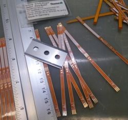 Taśmy FPC z odsłoniętymi końcówkami i metalowa płytka z trzema otworami
