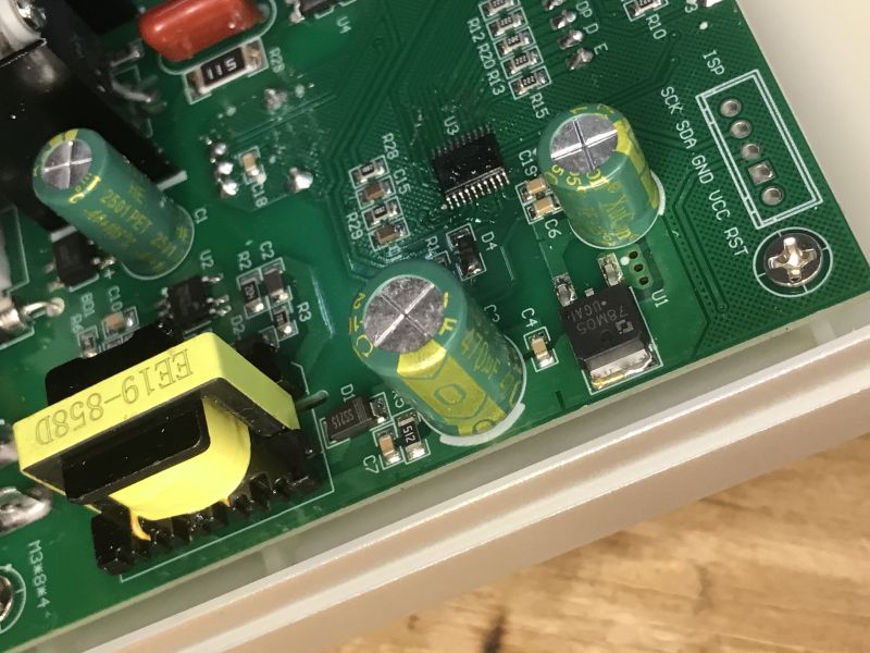 Zbliżenie na wnętrze stacji lutowniczej z widocznymi kondensatorami i elementami PCB