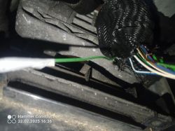 Zbliżenie na wiązkę przewodów samochodowych z różnokolorowymi kablami i opaską termokurczliwą.