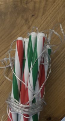 Świąteczne lampki LED owinięte wokół plastikowych lasek w kolorach biało-czerwono-zielonym