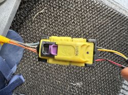 Zbliżenie na żółtą kostkę elektryczną z fioletowym zabezpieczeniem i czterema przewodami