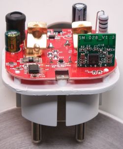 Close-up of a red PCB smart plug labeled SM-028_V1.3 with attached electronic components.