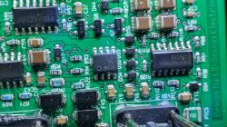 Płytka drukowana z elementami elektronicznymi i śladami przypalenia.