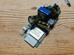 ESPC2-05 Module with Visible Capacitors Electronic module with capacitors and a chip on a wooden surface.