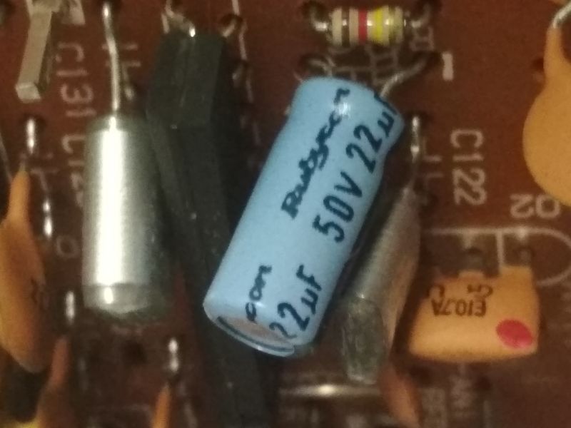 Zbliżenie na niebieski kondensator elektrolityczny Rubycon 50V 22µF na płytce drukowanej.
