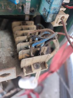 Zbliżenie na wewnętrzne części spawarki z widocznymi przewodami i złączami elektrycznymi.