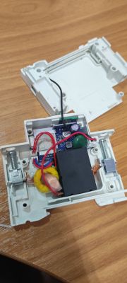 Interior of an electronic device in opened plastic casing Disassembled plastic casing with electronic components on a wooden surface