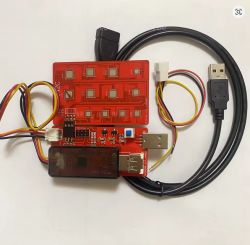 Czerwona płytka testowa z przyciskami, złączami USB i kablami zasilającymi