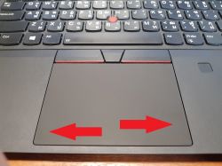 Touchpad laptopa Lenovo ThinkPad T490 z zaznaczonymi strzałkami w dolnych rogach wskazującymi miejsce kliknięcia.