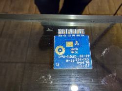 Tuya Mini Smart Switch PCB Disassembled PCB of the Tuya Mini Smart Switch on a glass surface.