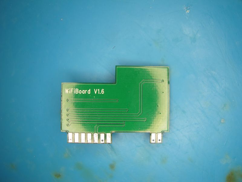 Green PCB labeled WiFiBoard V1.6 on a blue surface