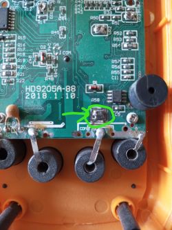 Close-up of the DT9205A+ multimeter circuit board with burnt resistors marked in green.