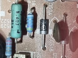 Zbliżenie na komponenty elektroniczne na płytce drukowanej, w tym diody i rezystory.