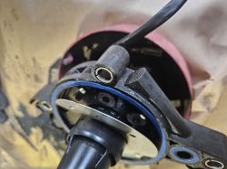 Zbliżenie na element mechaniczny z okrągłą blaszką, trzema podkładkami na krótkich kołkach umieszczonych pomiędzy dwiema blaszkami.