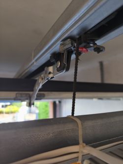 Wnętrze prowadnicy bramy garażowej z mechanizmem i linką do otwierania